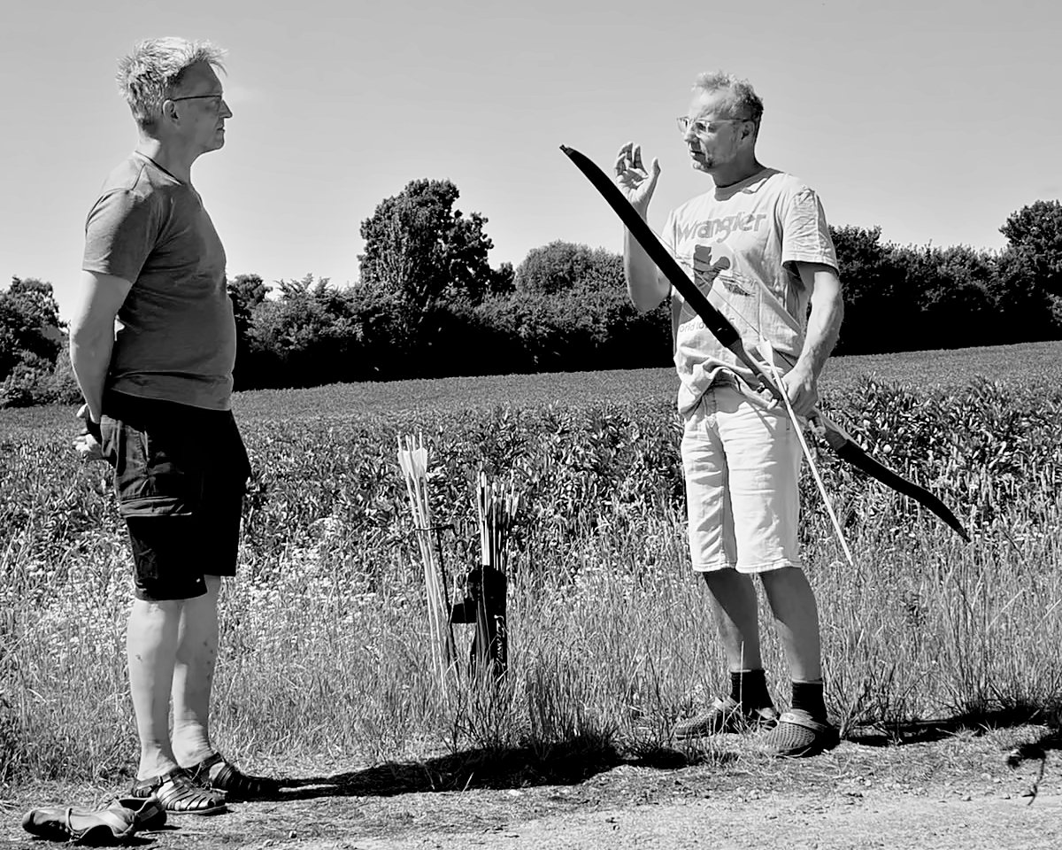 Thomas Lücke im Gespräch mit einem Gast beim Bogenschießen am Feldrand