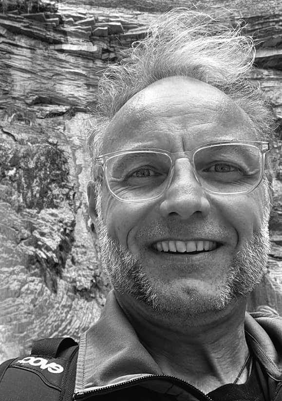 Thomas Lücke lächelnd vor einer Felswand
